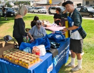 A man in front of North Hollywood West Neighborhood Council table at Fir Fest