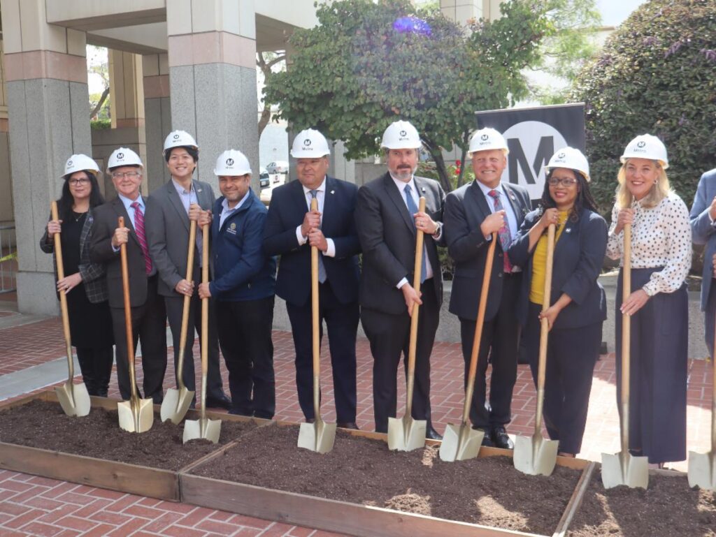 9 People holding shovels at a groundbreaking